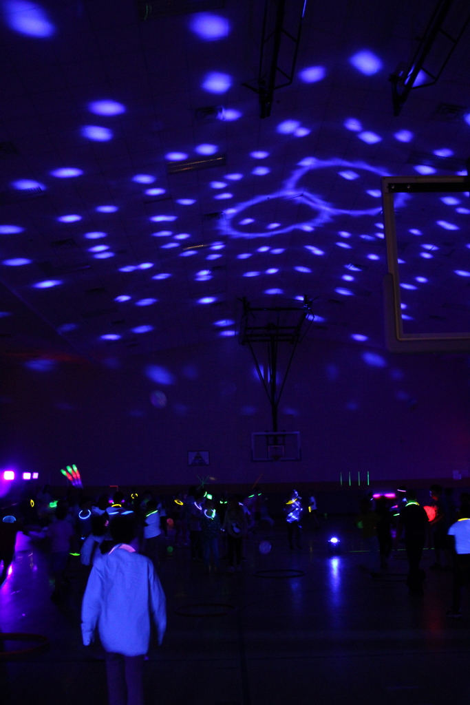 Dark gym with neon colors projected on wall.