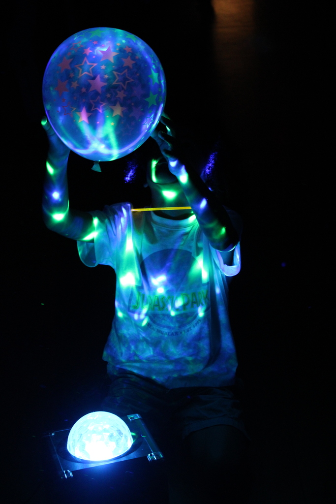 Student playing with clear blow up ball with neon highlights